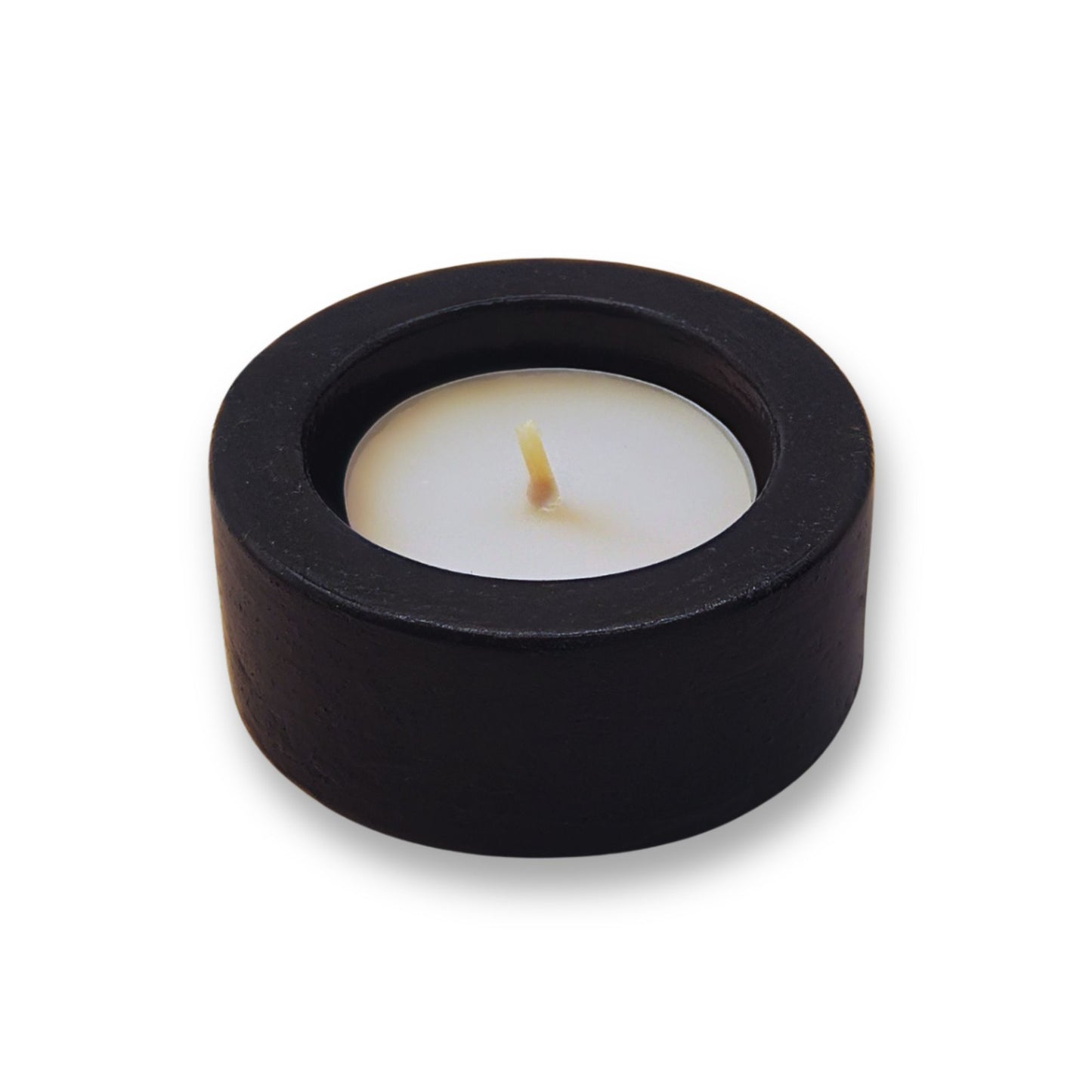 Black candle holder with a white candle on a white background