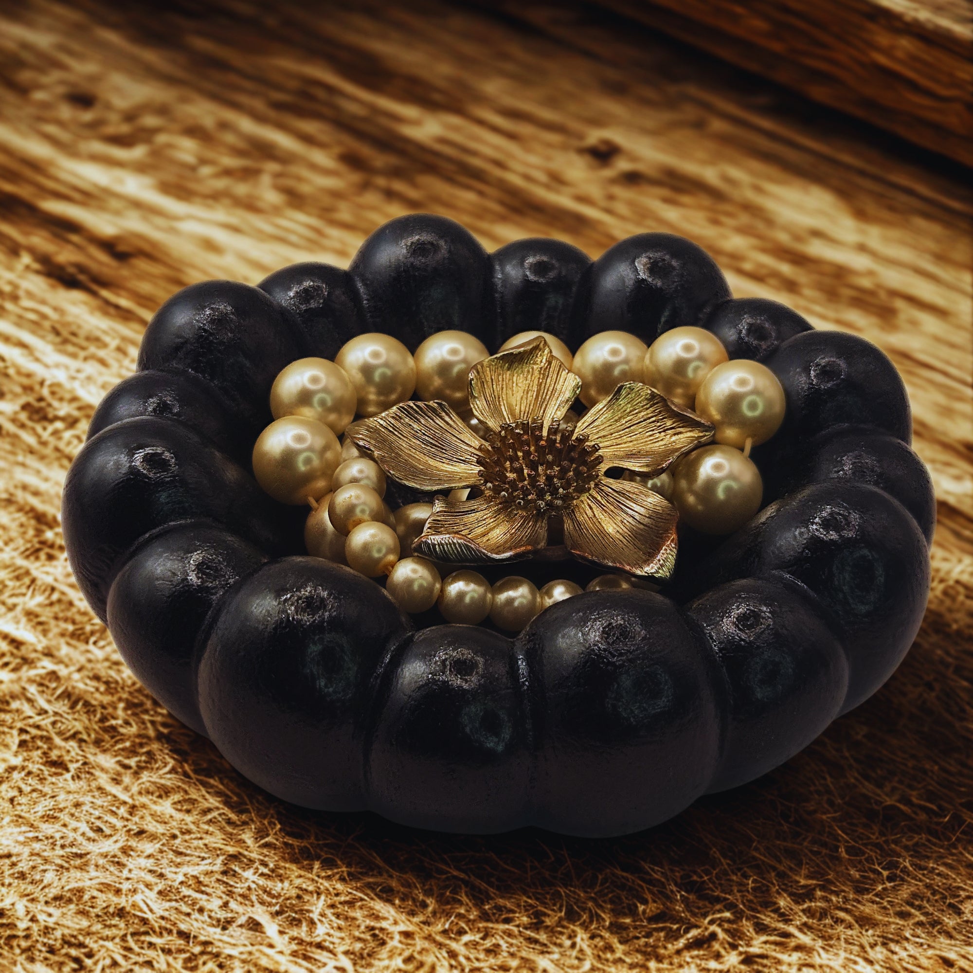 A black decorative bowl holding jewellery