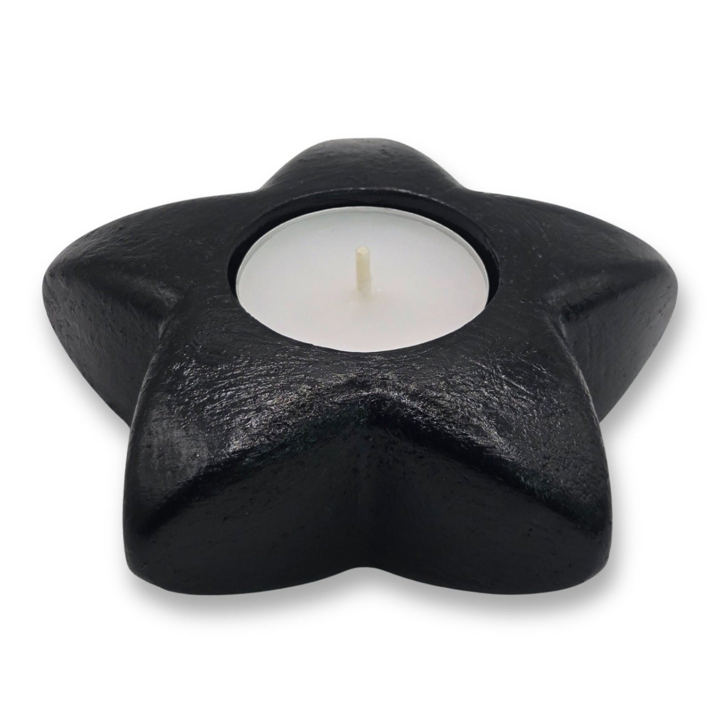 Black star-shaped candle holder with a white candle inside on a white background