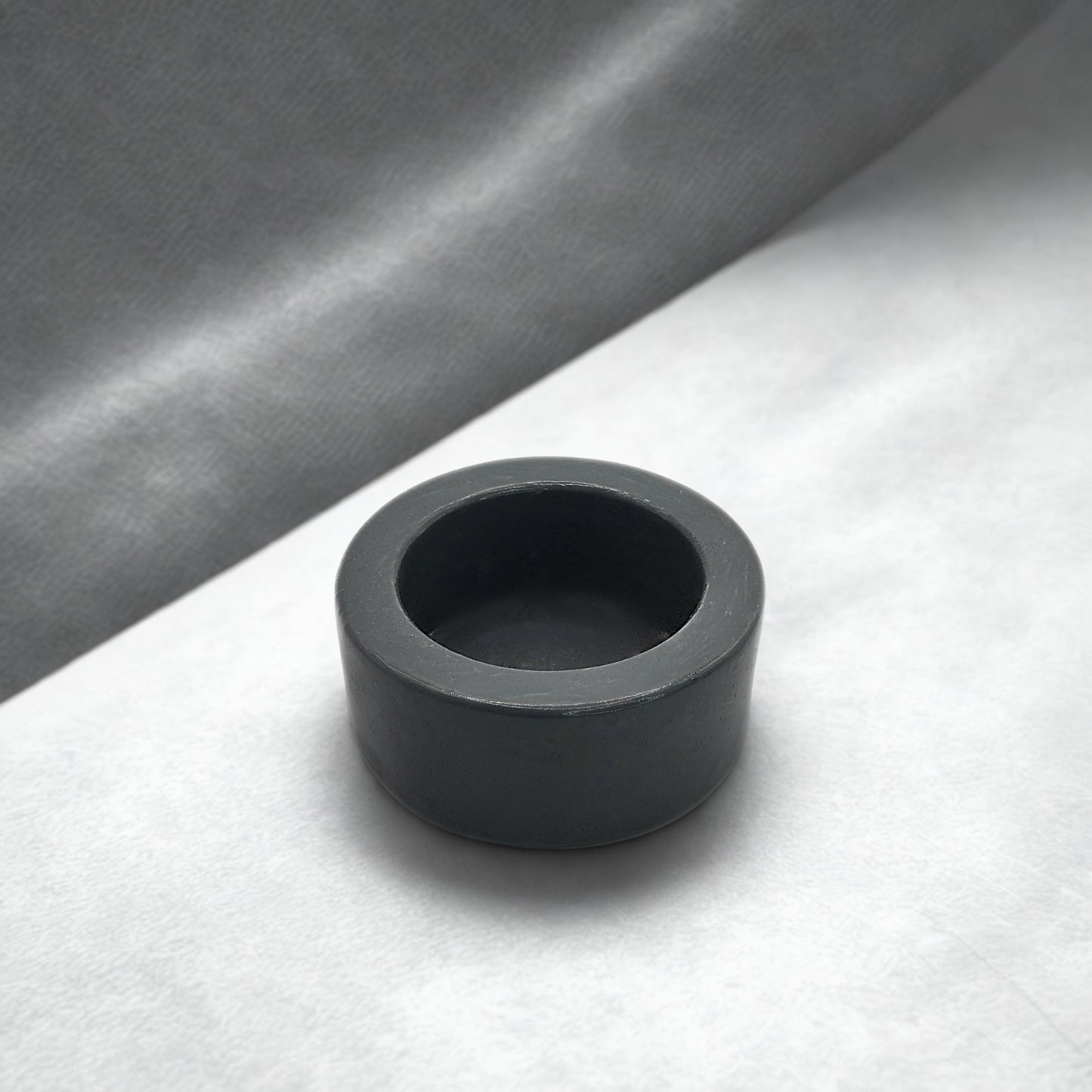 Grey round tealight holder on a gray and white background