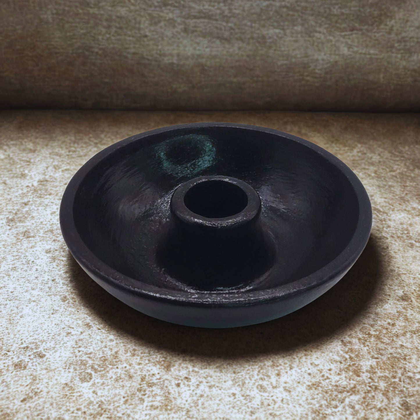 Black round item on a textured surface