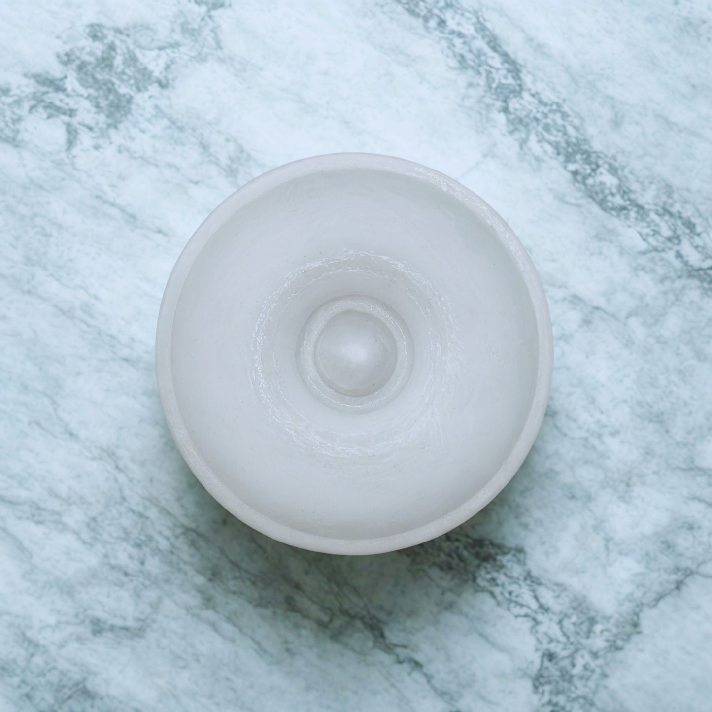 White round item on a marble surface