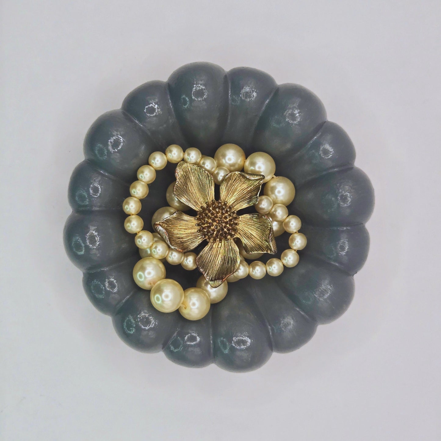 Decorative Cloud Jewellery Bowl with a gold flower and pearl necklace on a light gray background