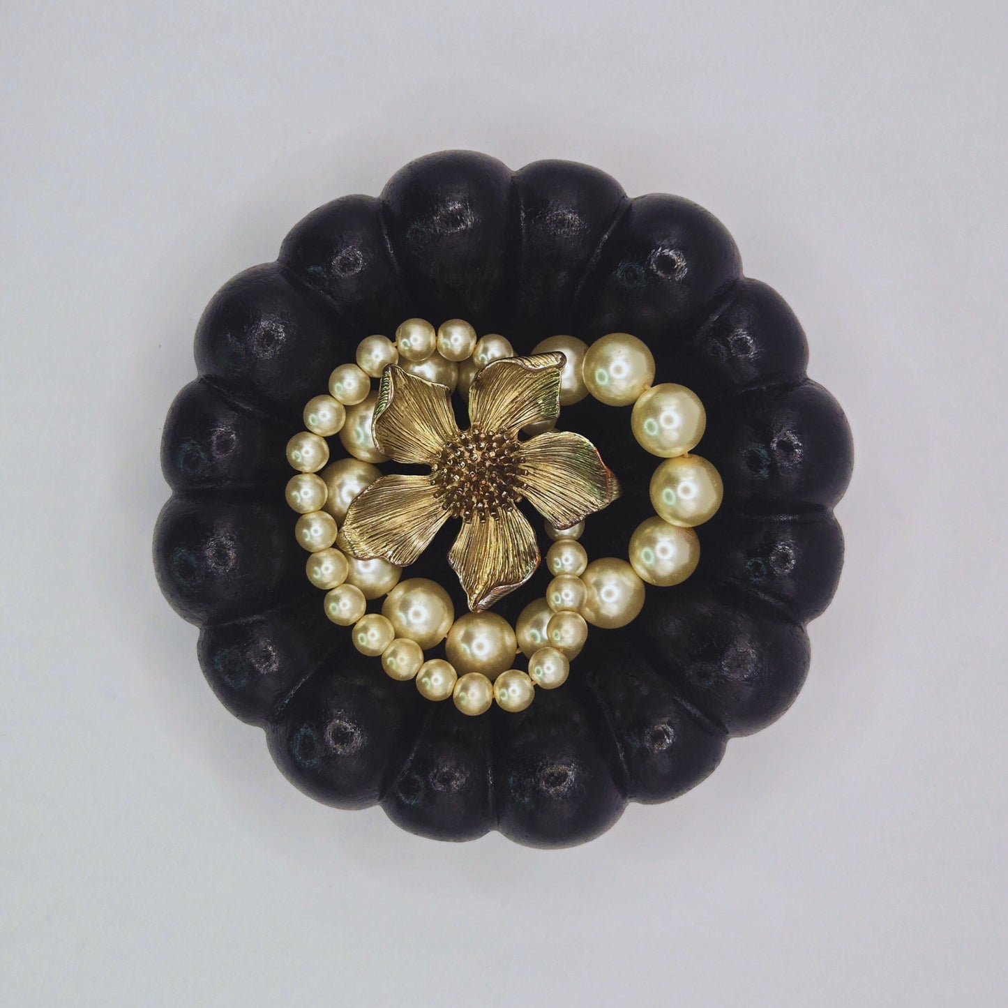Black Cloud Jewellery Bowl with pearl and gold flower design on a light gray background