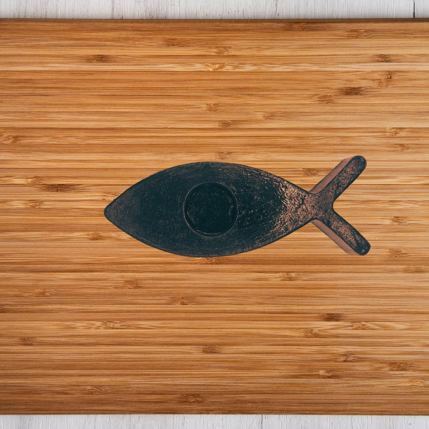 Black fish candle holder on a wooden surface