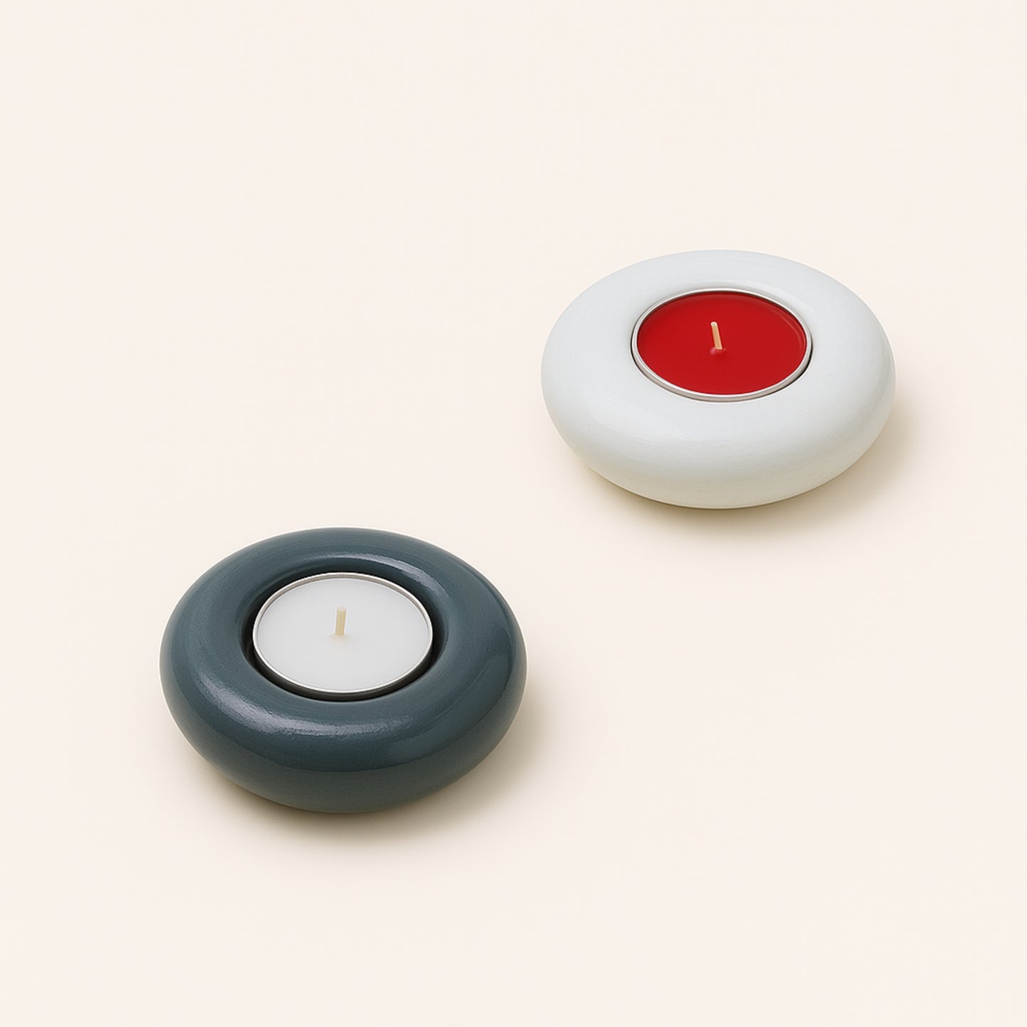 Two candle holders with candles inside on a light beige background