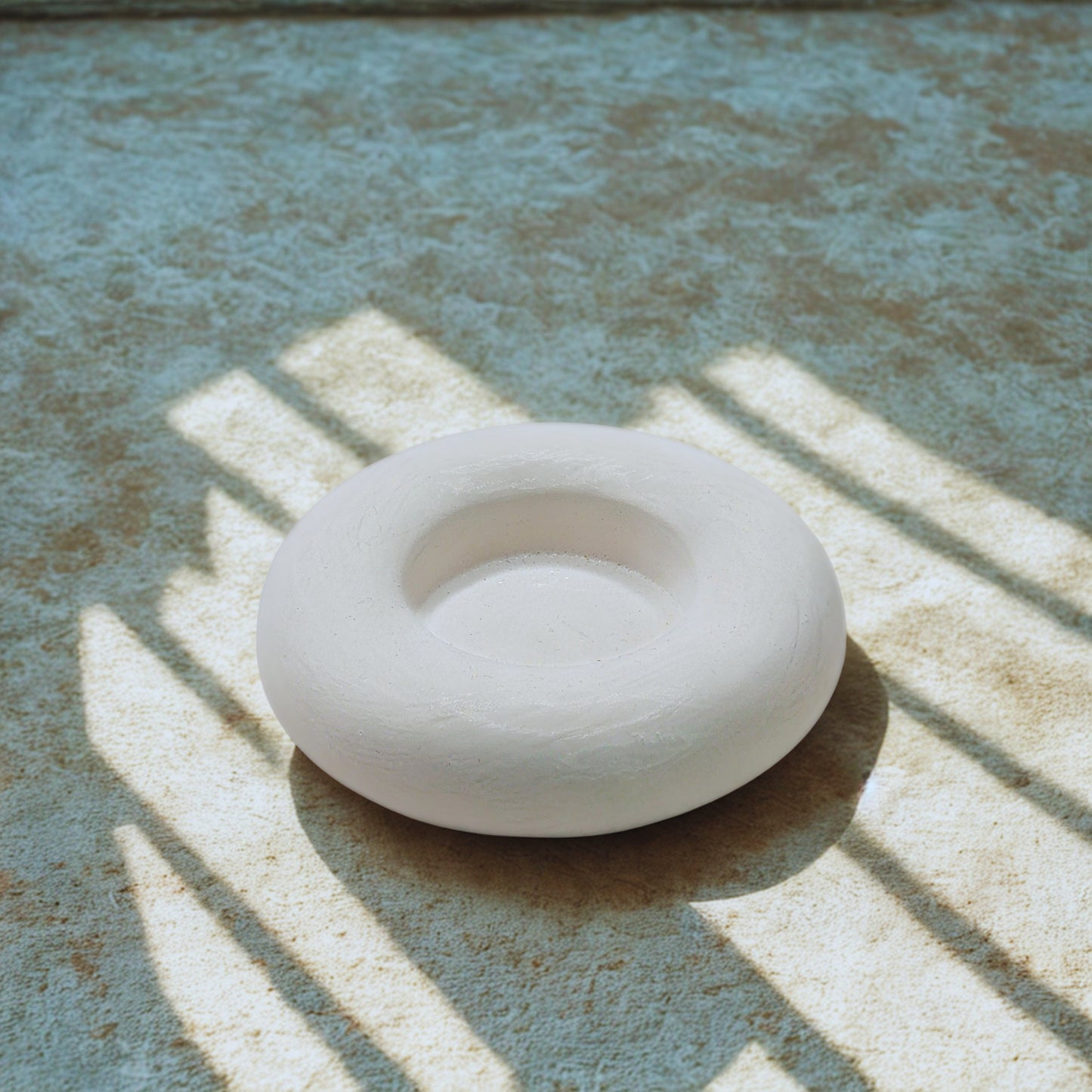 White object on a textured surface with shadows