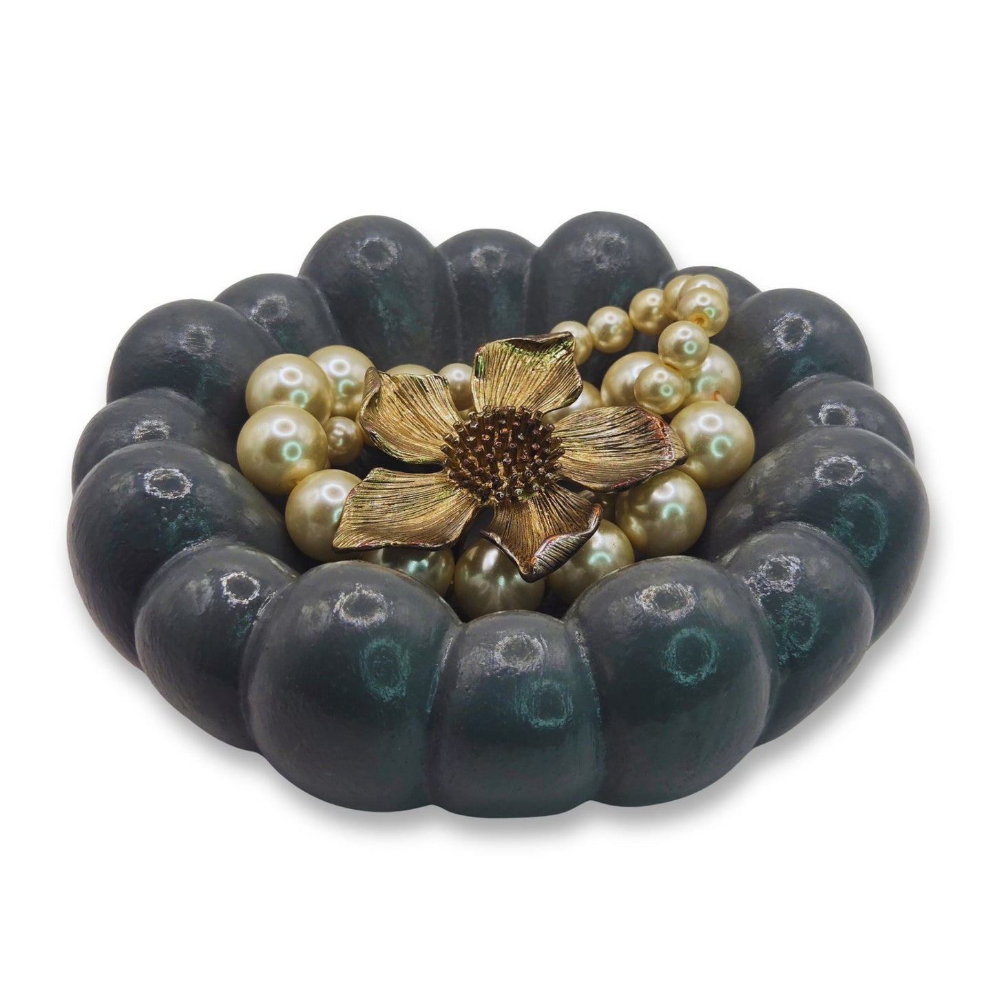 Bracelet with dark beads and pearl-like stones featuring a gold flower clasp on a white background