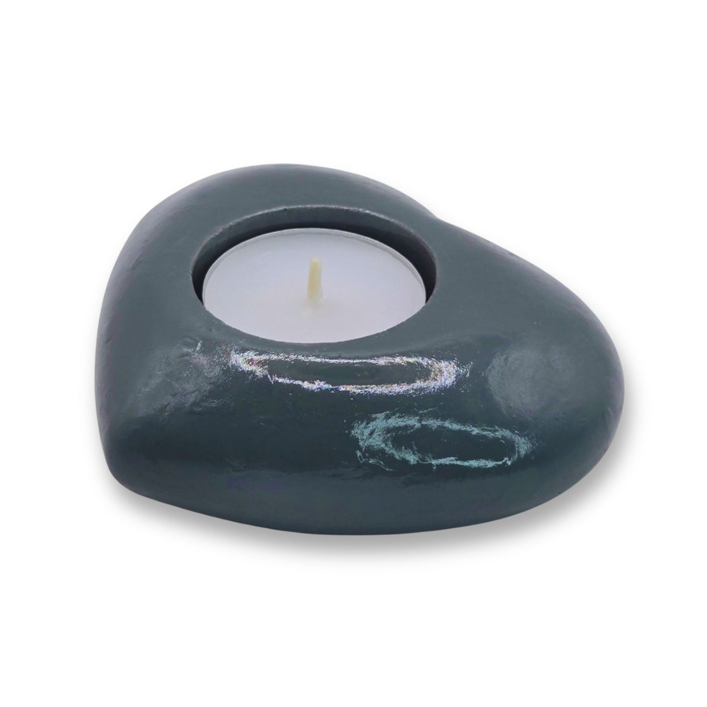Heart-shaped dark gray candle holder with a white candle on a white background