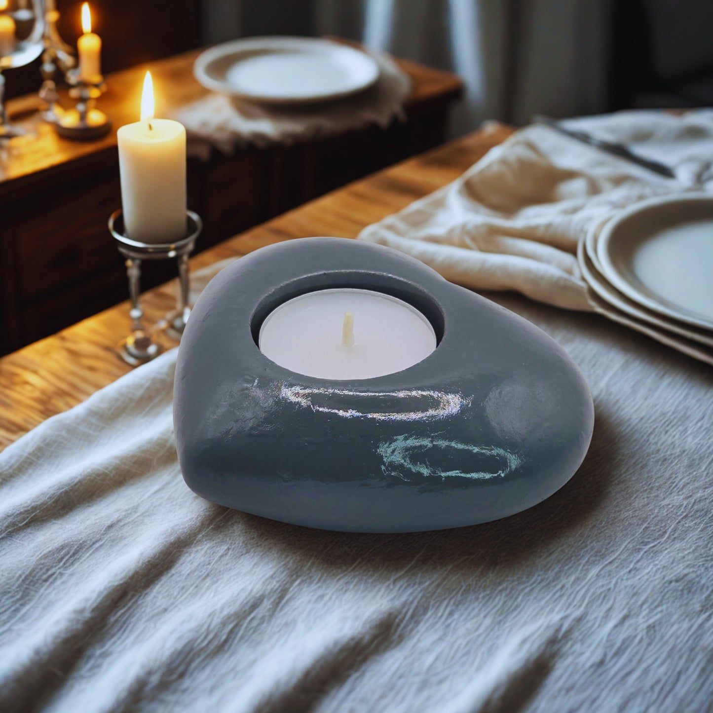 Object with a lit candle on a wooden table.