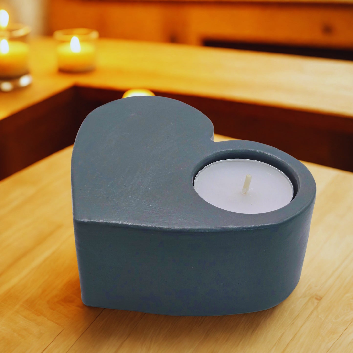 Heart-shaped candle holder with a lit candle on a wooden surface