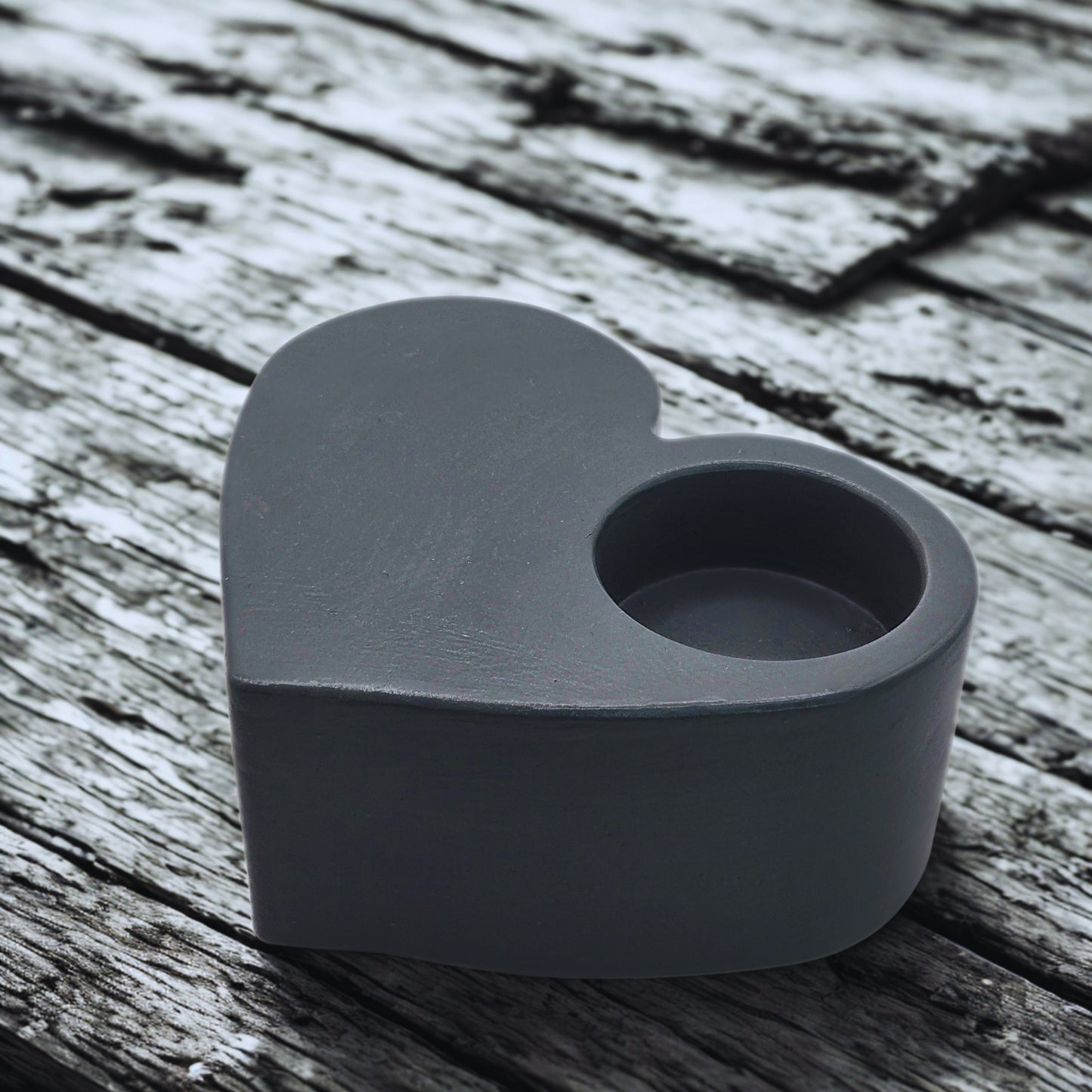 Heart-shaped gray object on a wooden surface
