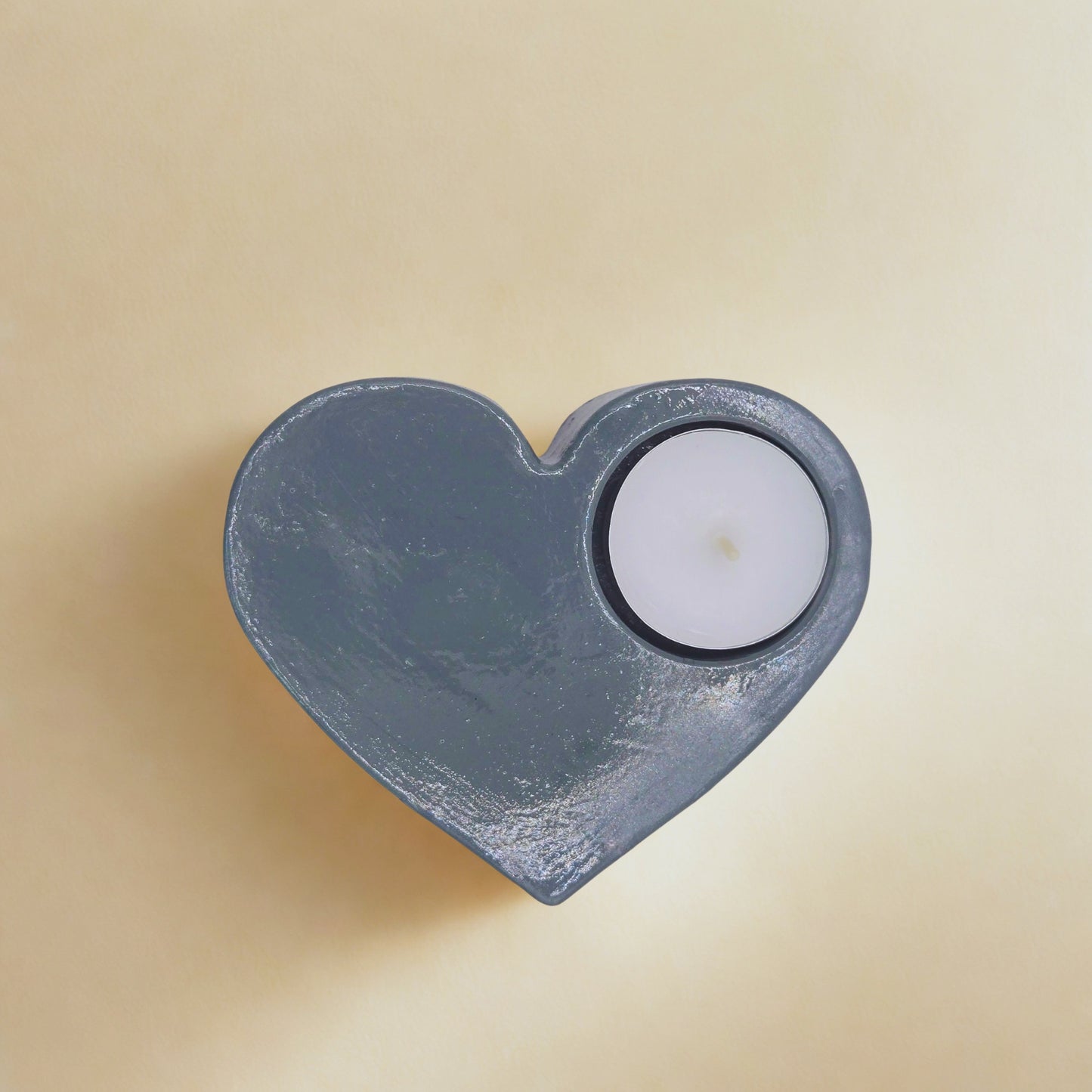 Large Heart tealight holder with a white candle on a beige background