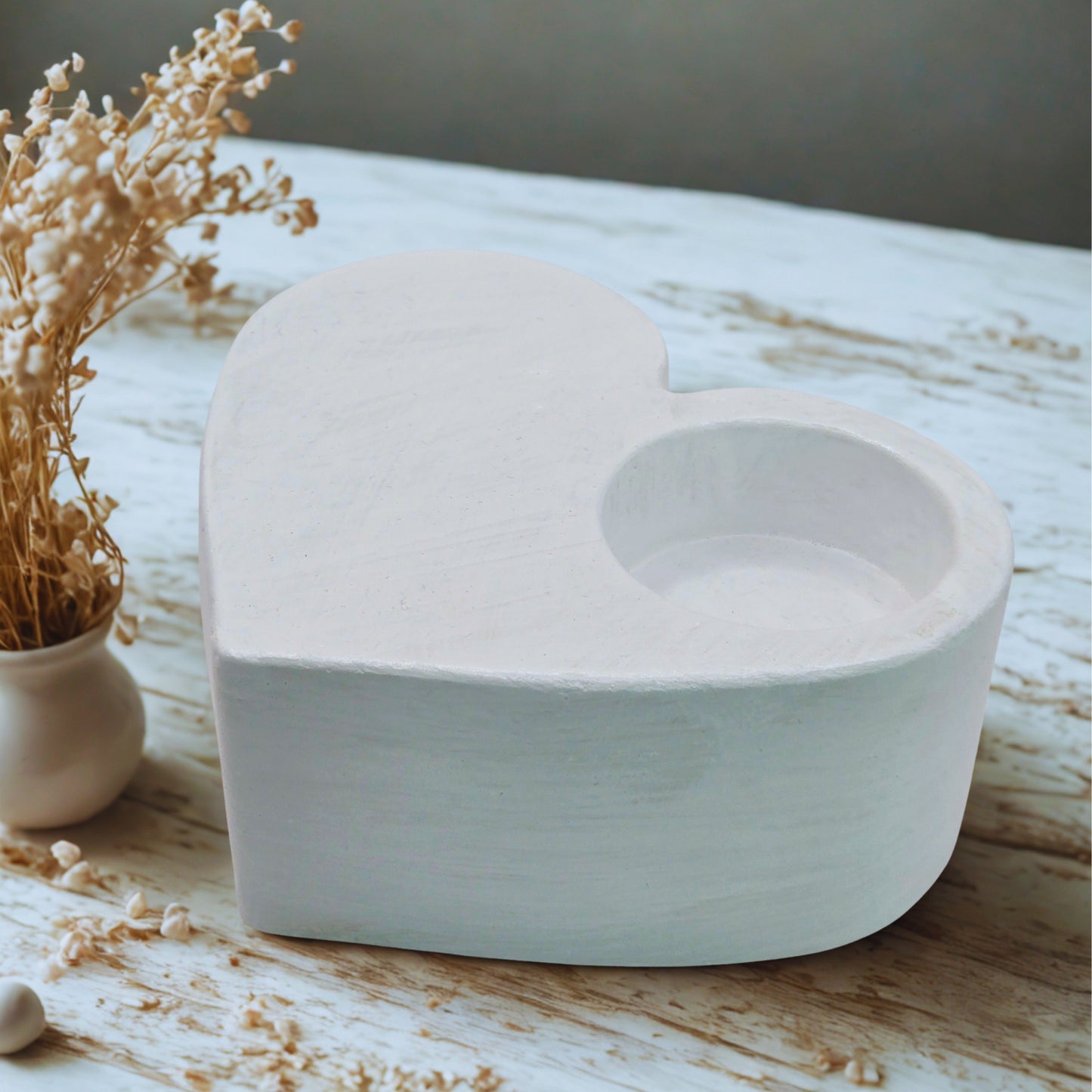 Large Heart tealight holder on a wooden surface with dried flowers.