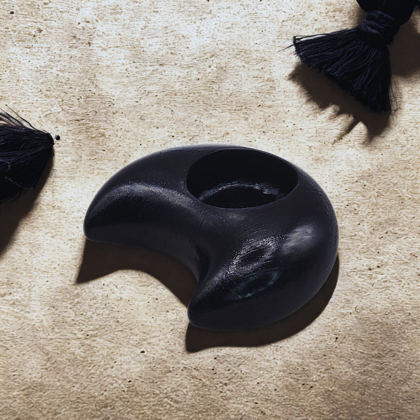 Black Moon tealight holder on a textured beige surface