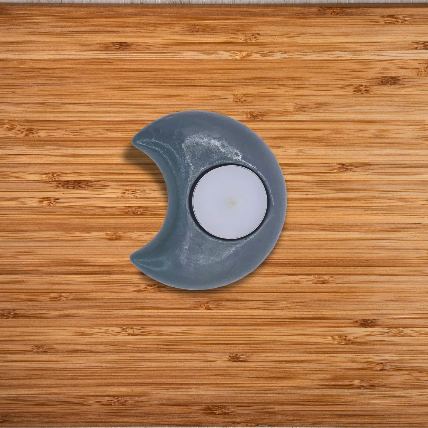 Decorative moon-shaped candle holder on a wooden surface
