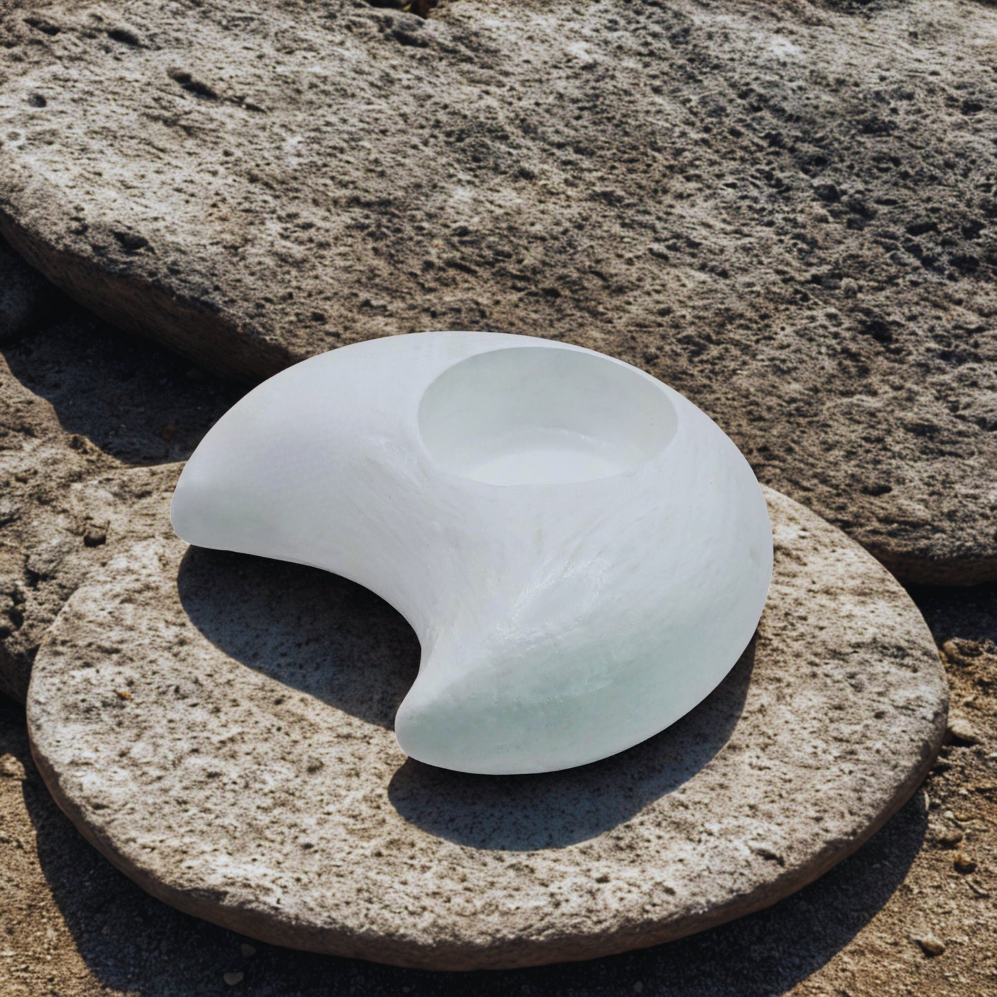 White Moon tealight holder on a textured stone surface