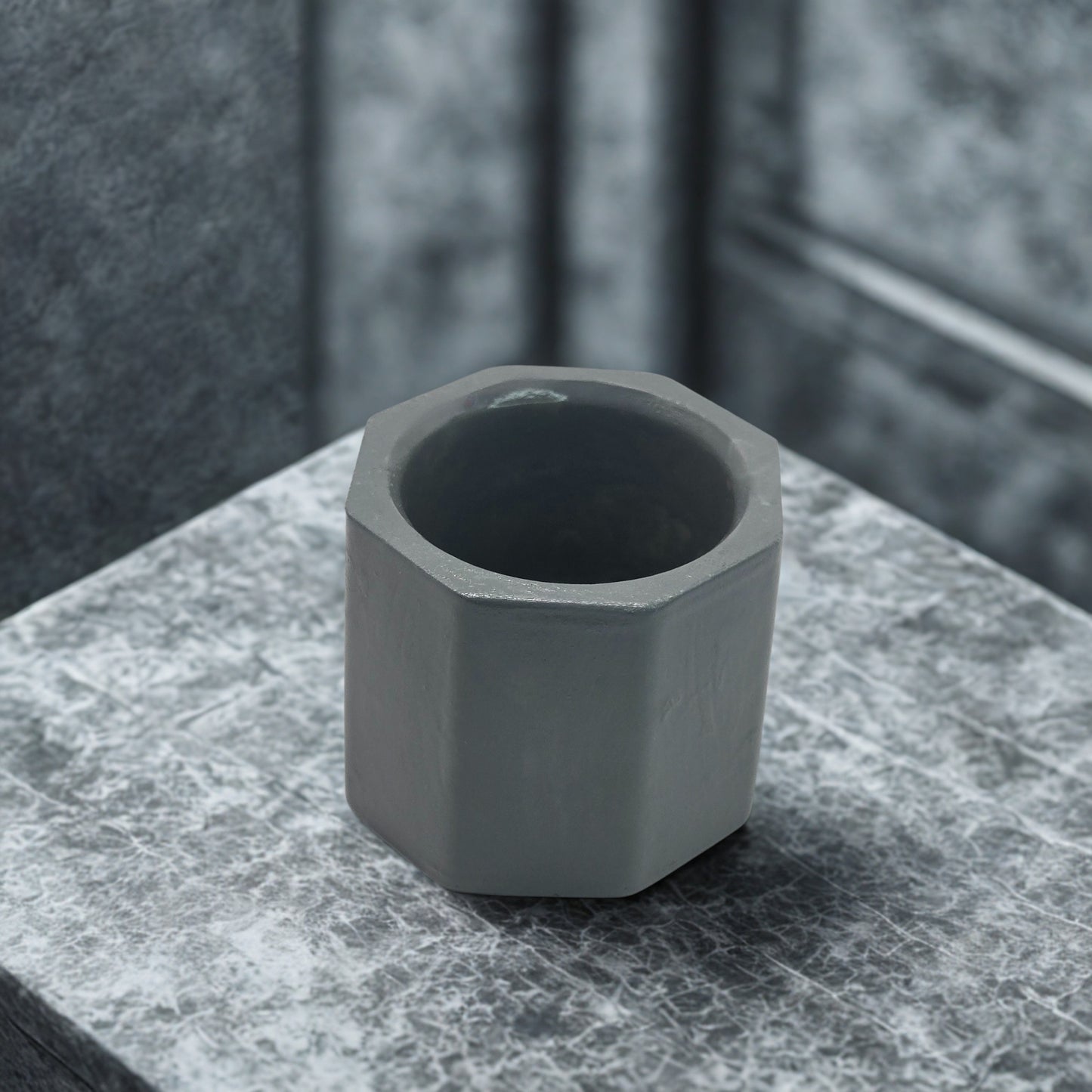 Octagon tealight holder on a marble surface with a blurred background