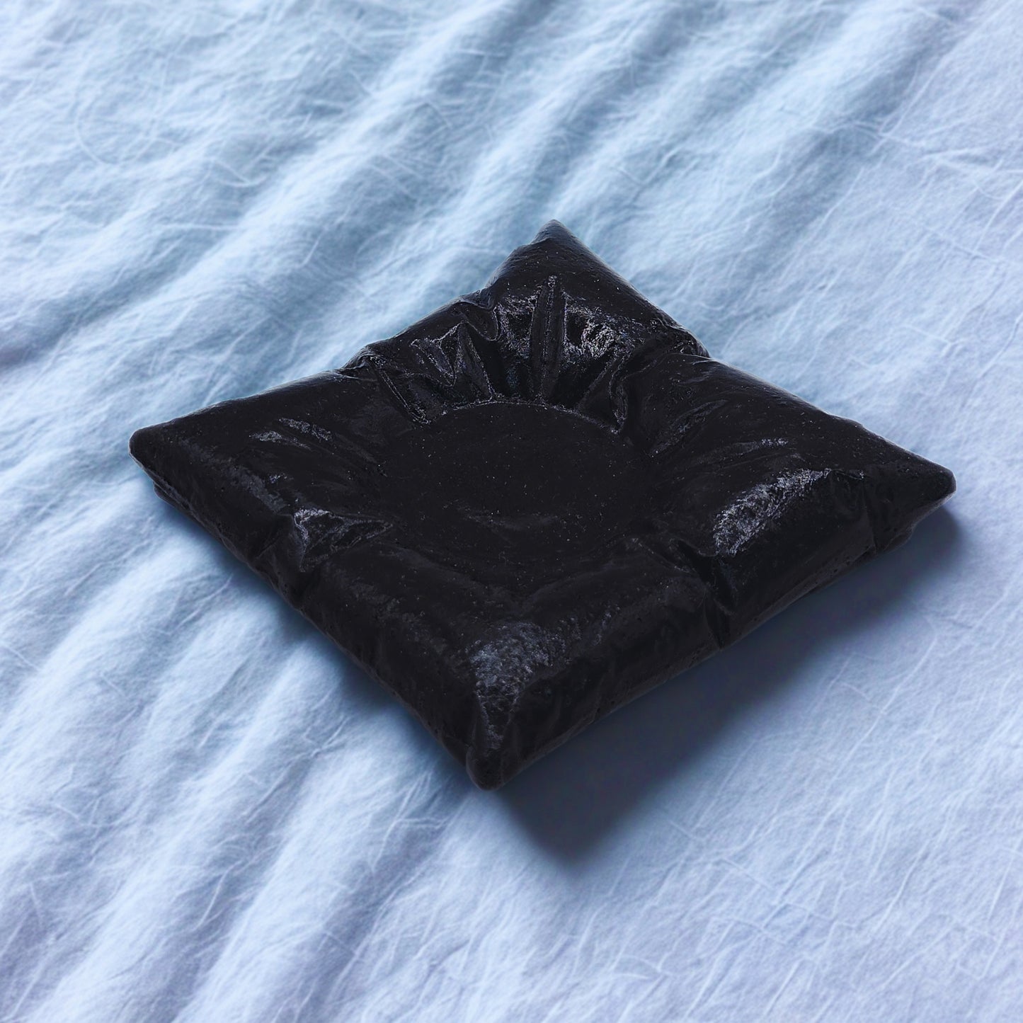 pillow tealight holder on a textured light blue surface