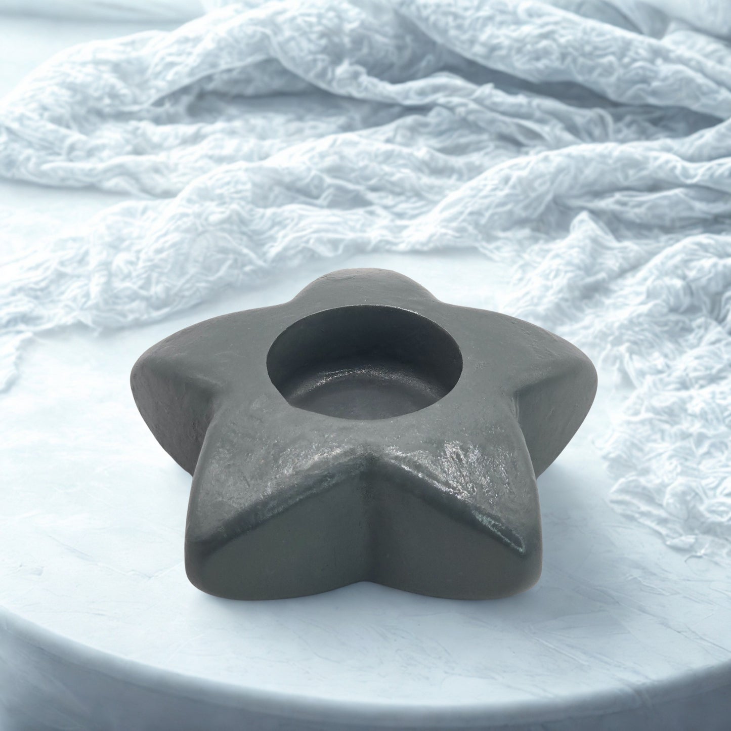 Star-shaped gray object on a textured white surface