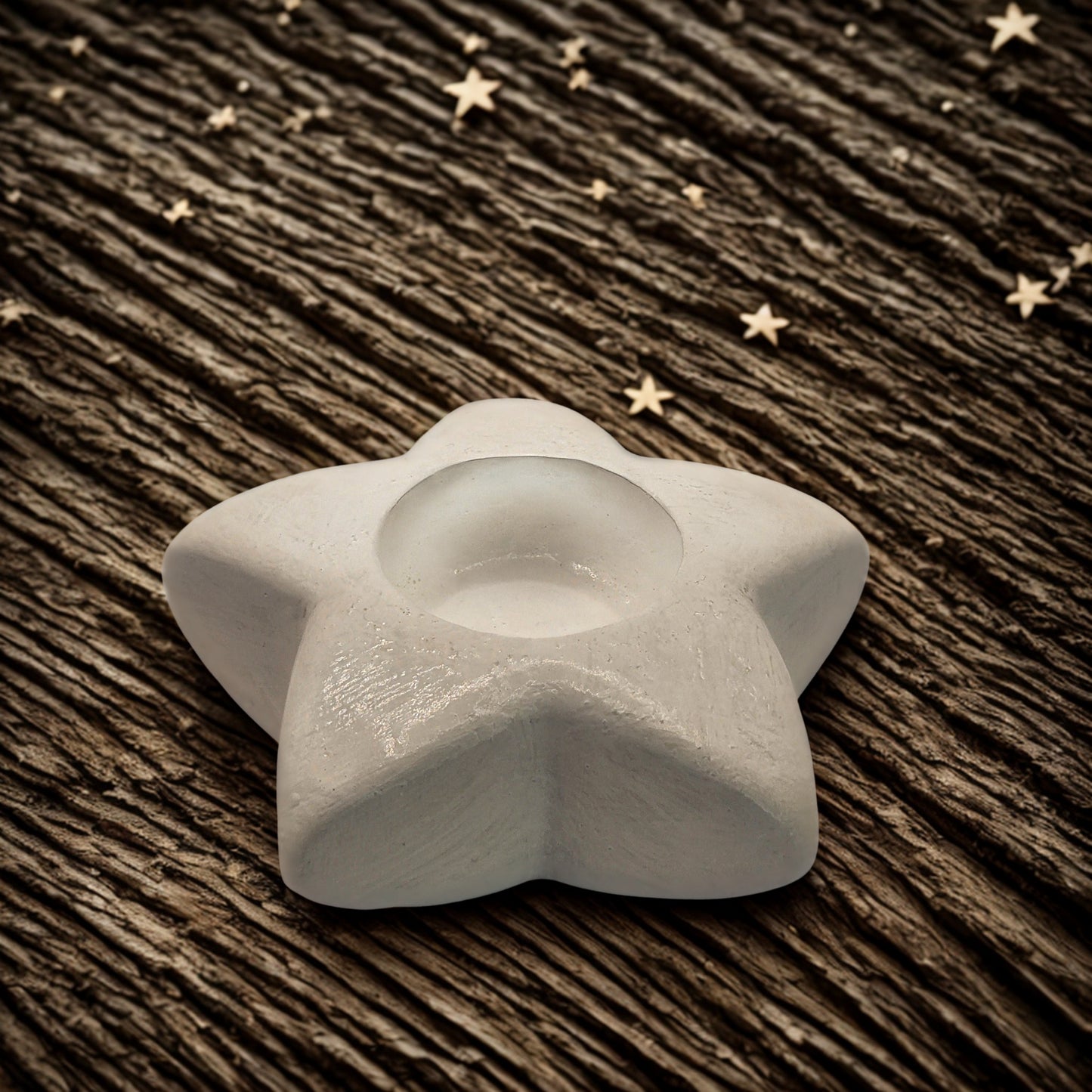 star tealight holder on a wooden surface with star decorations.