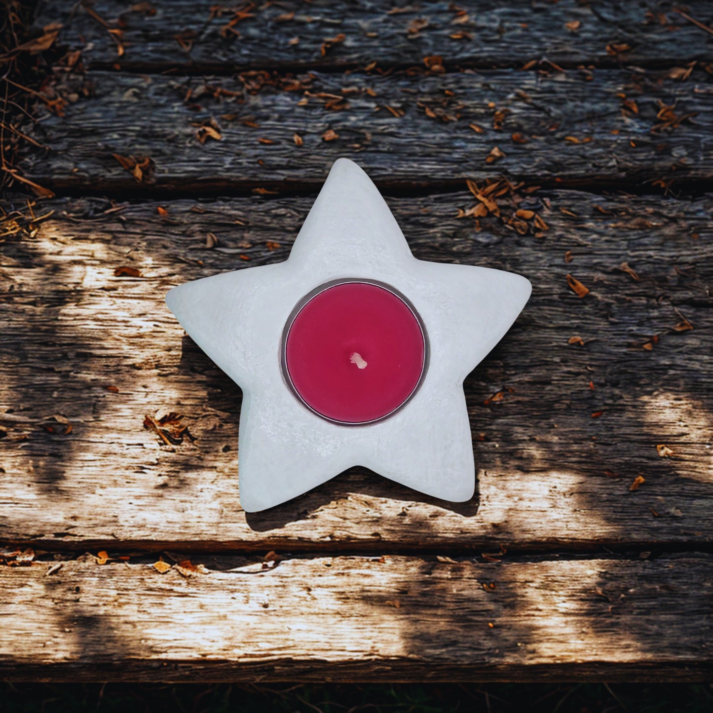 star tealight holder with a red candle on a wooden surface