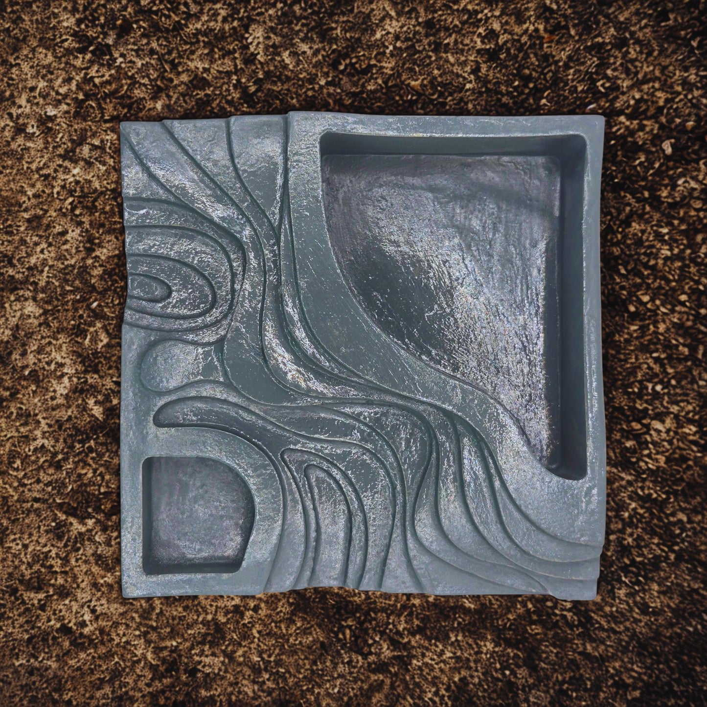 Decorative step planter with wavy pattern on a brown surface