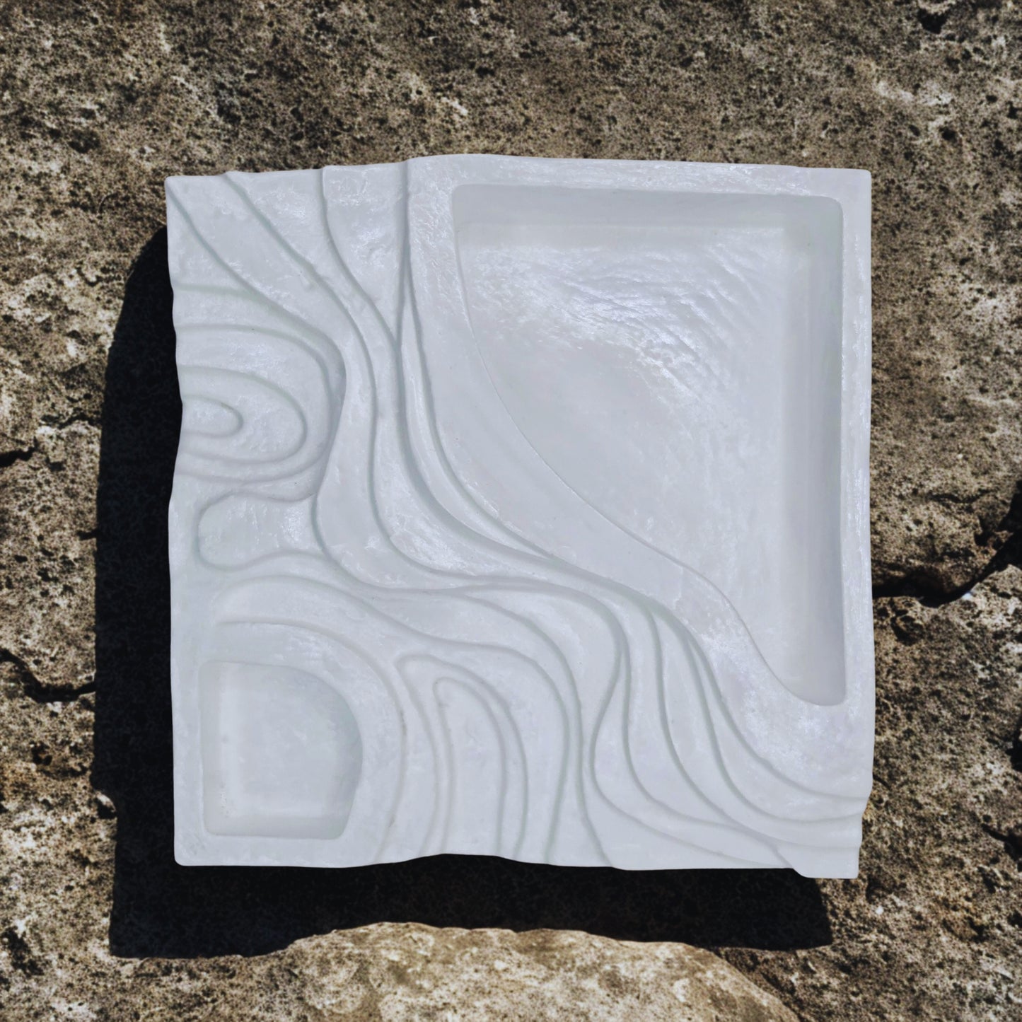 White object with embossed pattern on a textured brown surface
