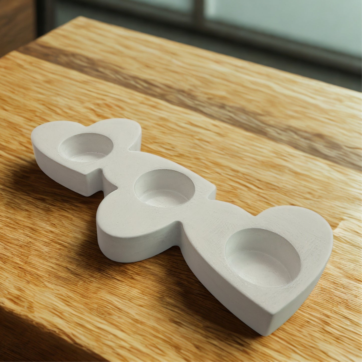 Triple Heart tealight holder on a wooden surface