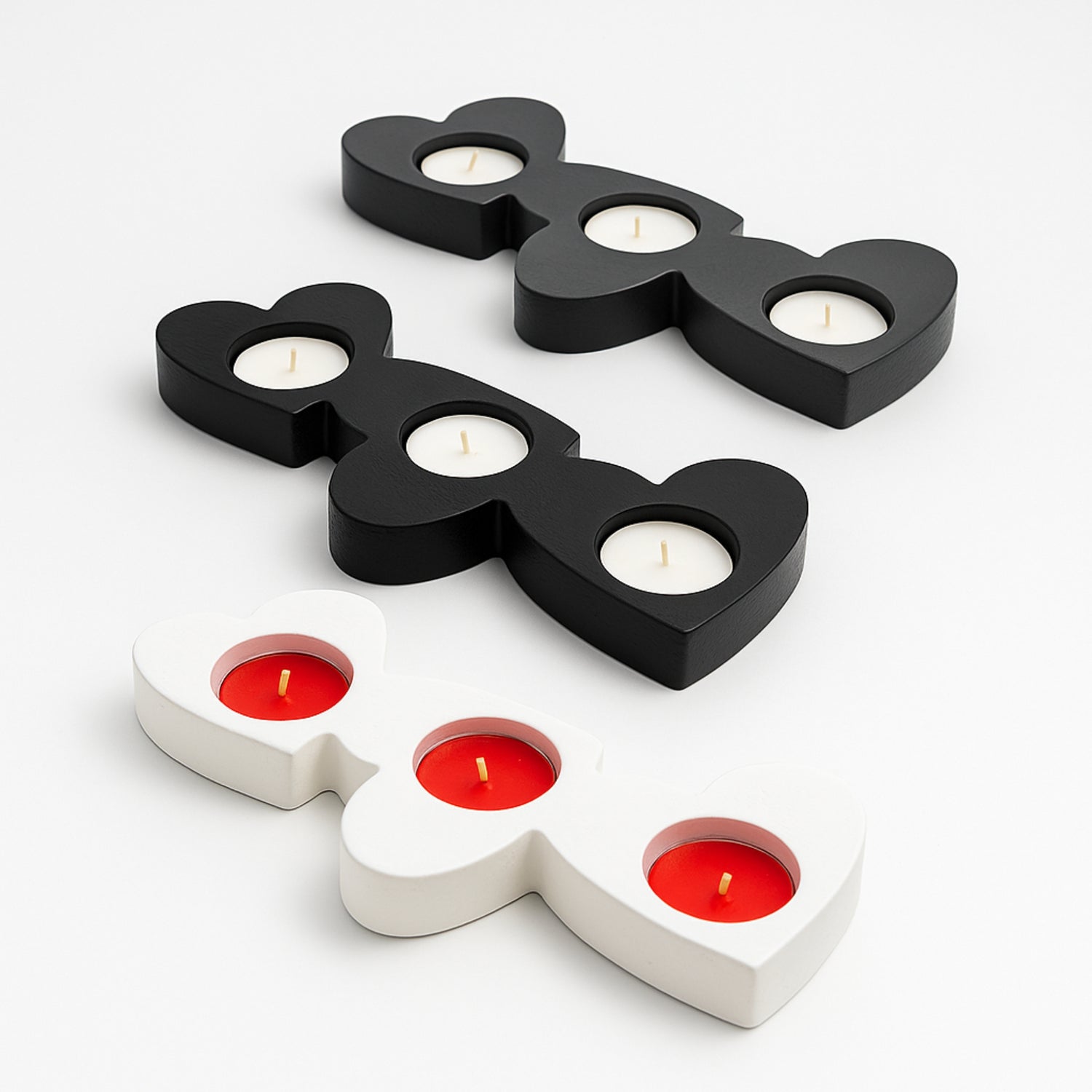 Black and white candle holders with lit candles on a white background