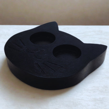 Black cat-shaped object on a white surface