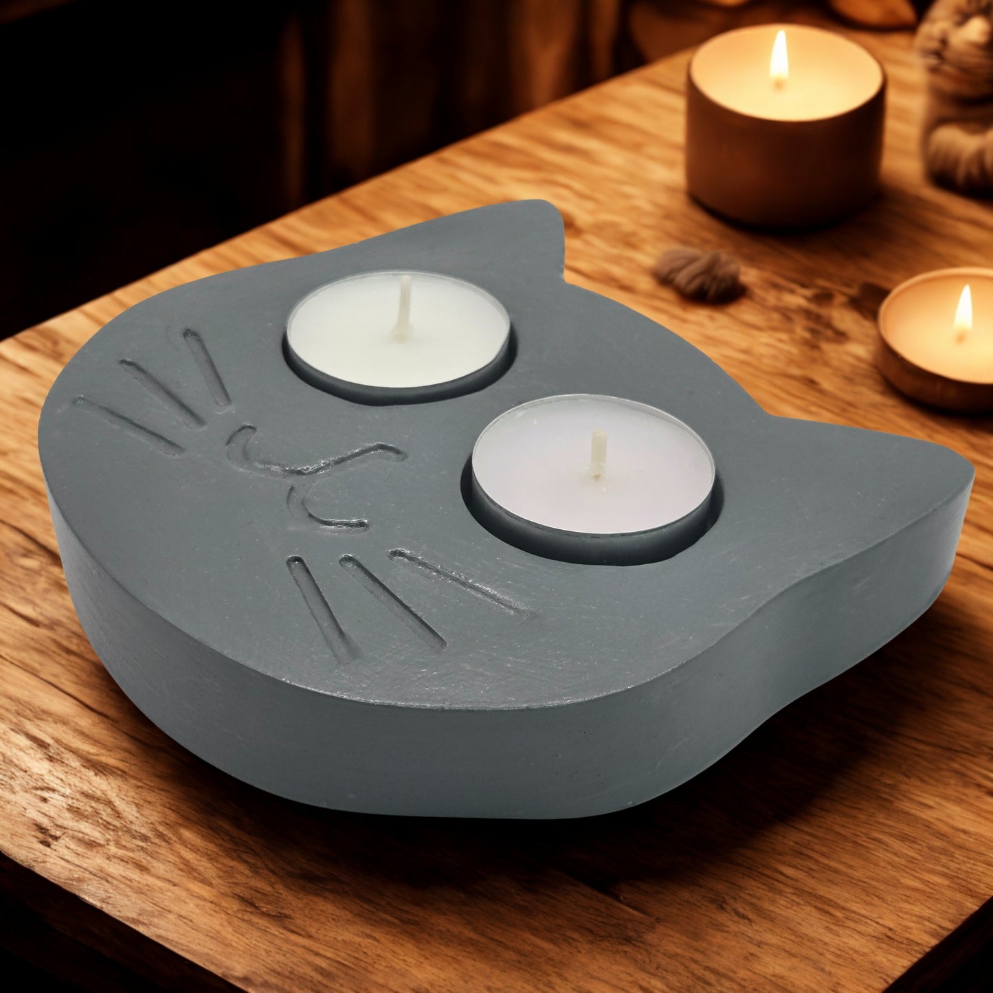 cat tealight holder with two candles on a wooden surface