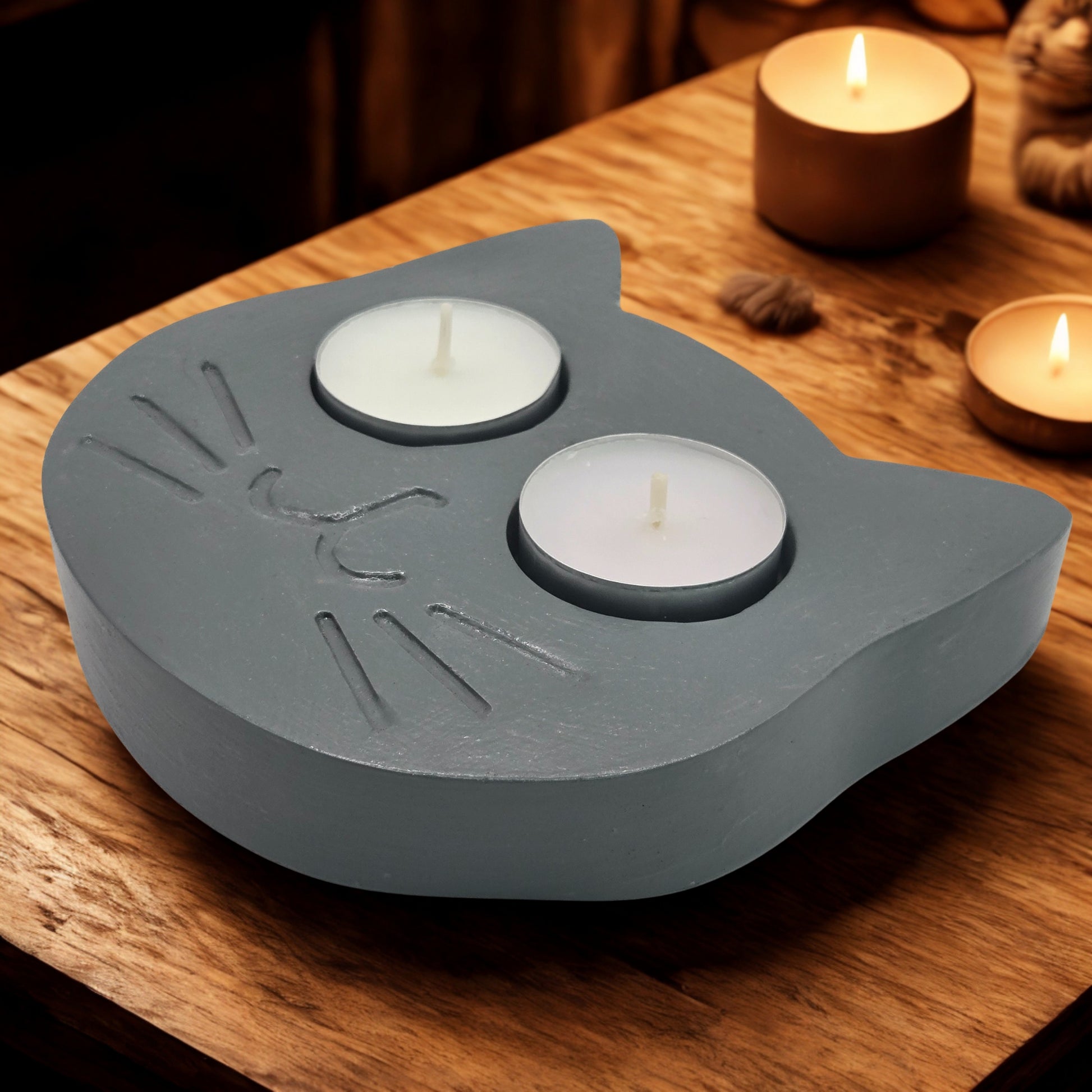 cat tealight holder with two candles on a wooden surface