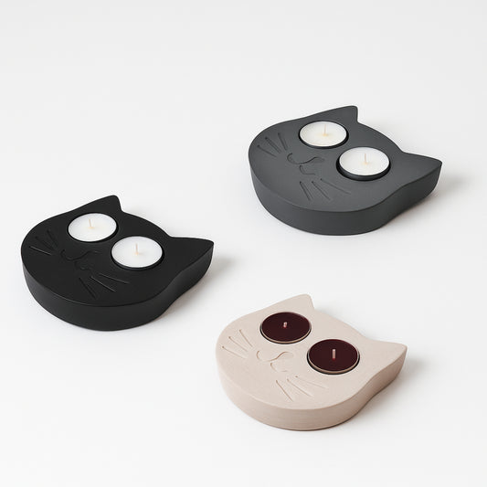 3 cat tealight holders, one grey, one black and one white, on a white background
