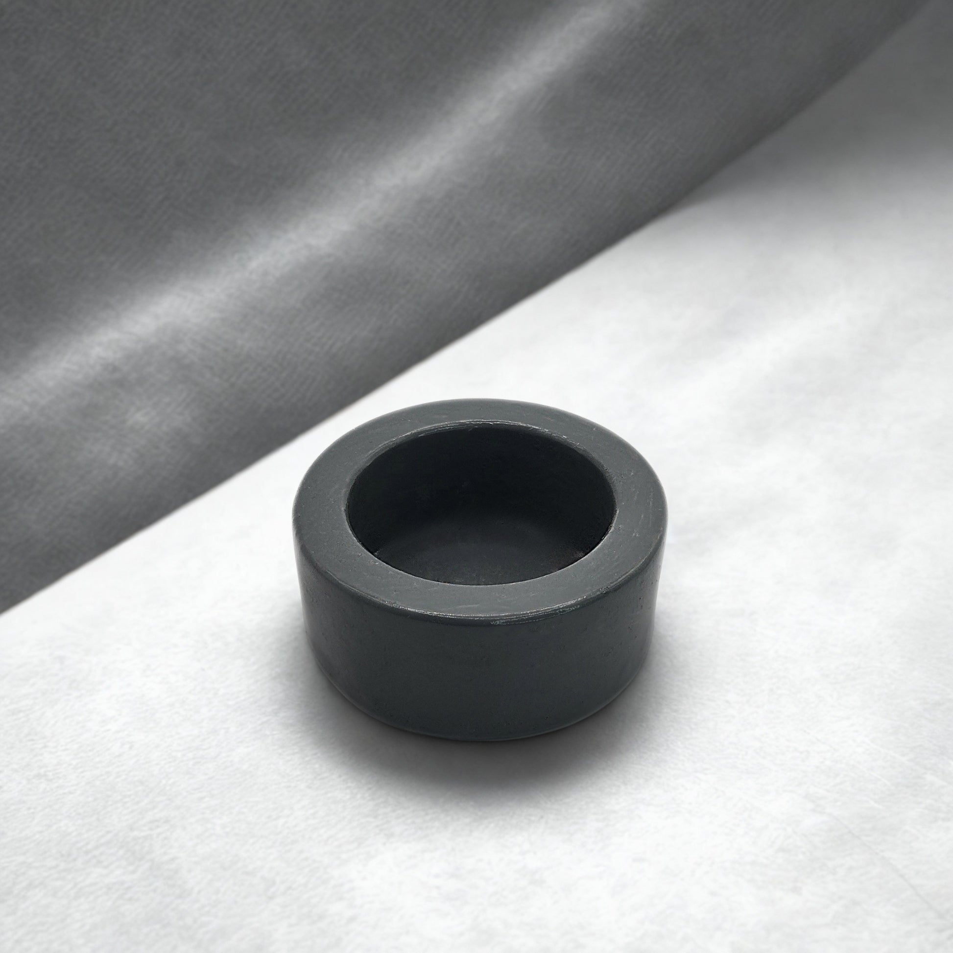 Grey round tealight holder on a gray and white background