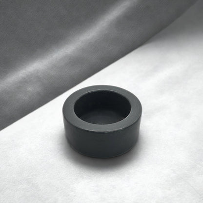 Grey round tealight holder on a gray and white background