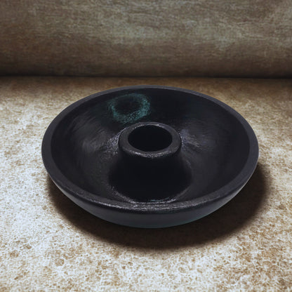 Black round item on a textured surface