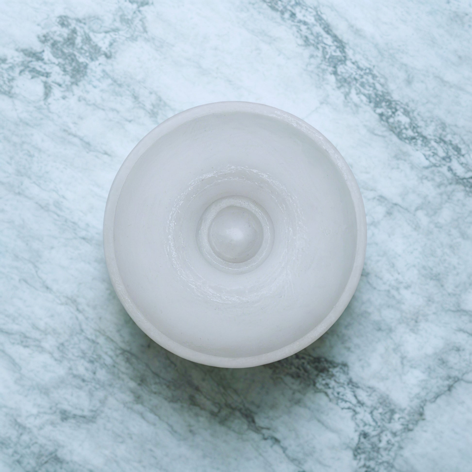 White round item on a marble surface