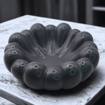 Grey cloud ashtray on a white surface with a blurred background