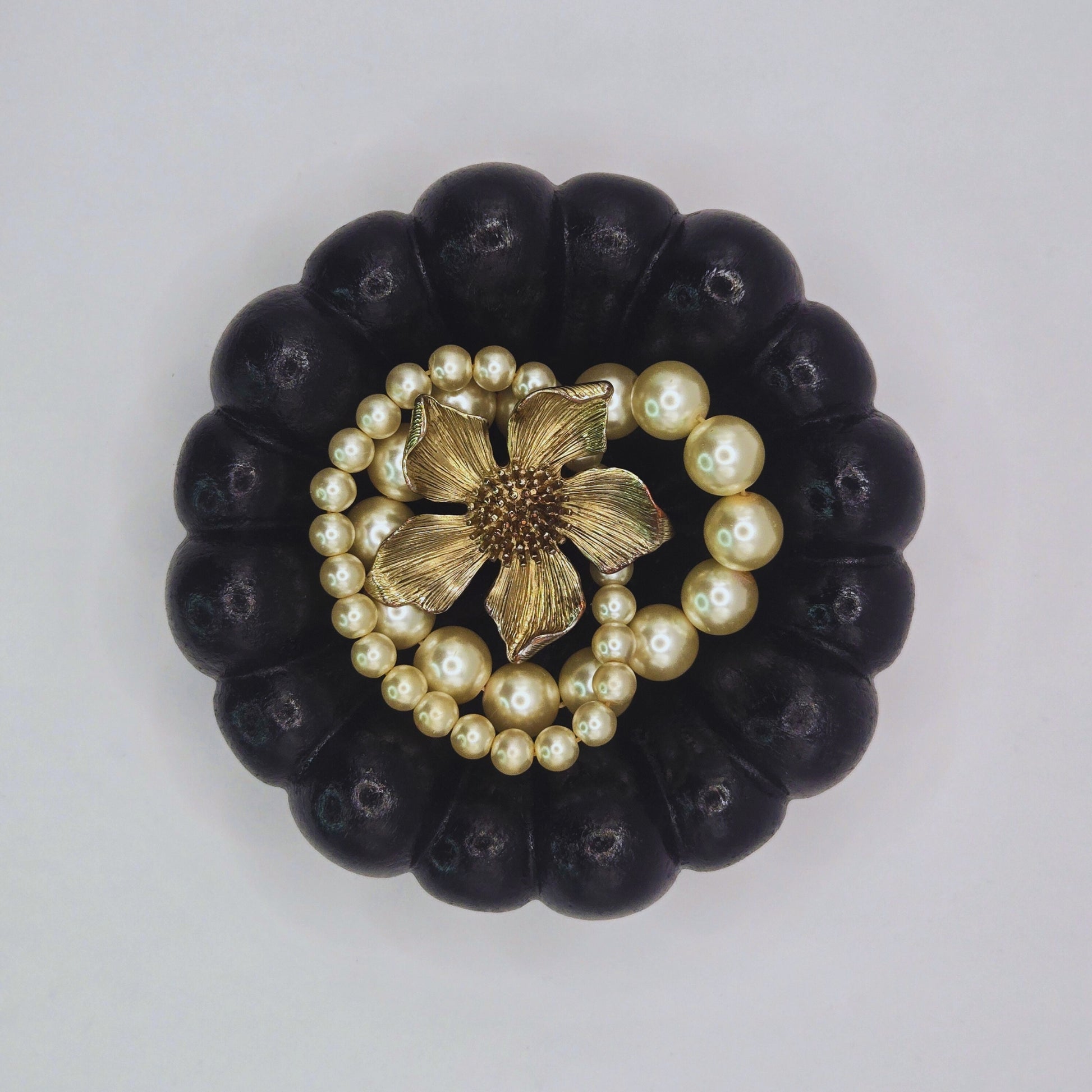Black Cloud Jewellery Bowl with pearl and gold flower design on a light gray background