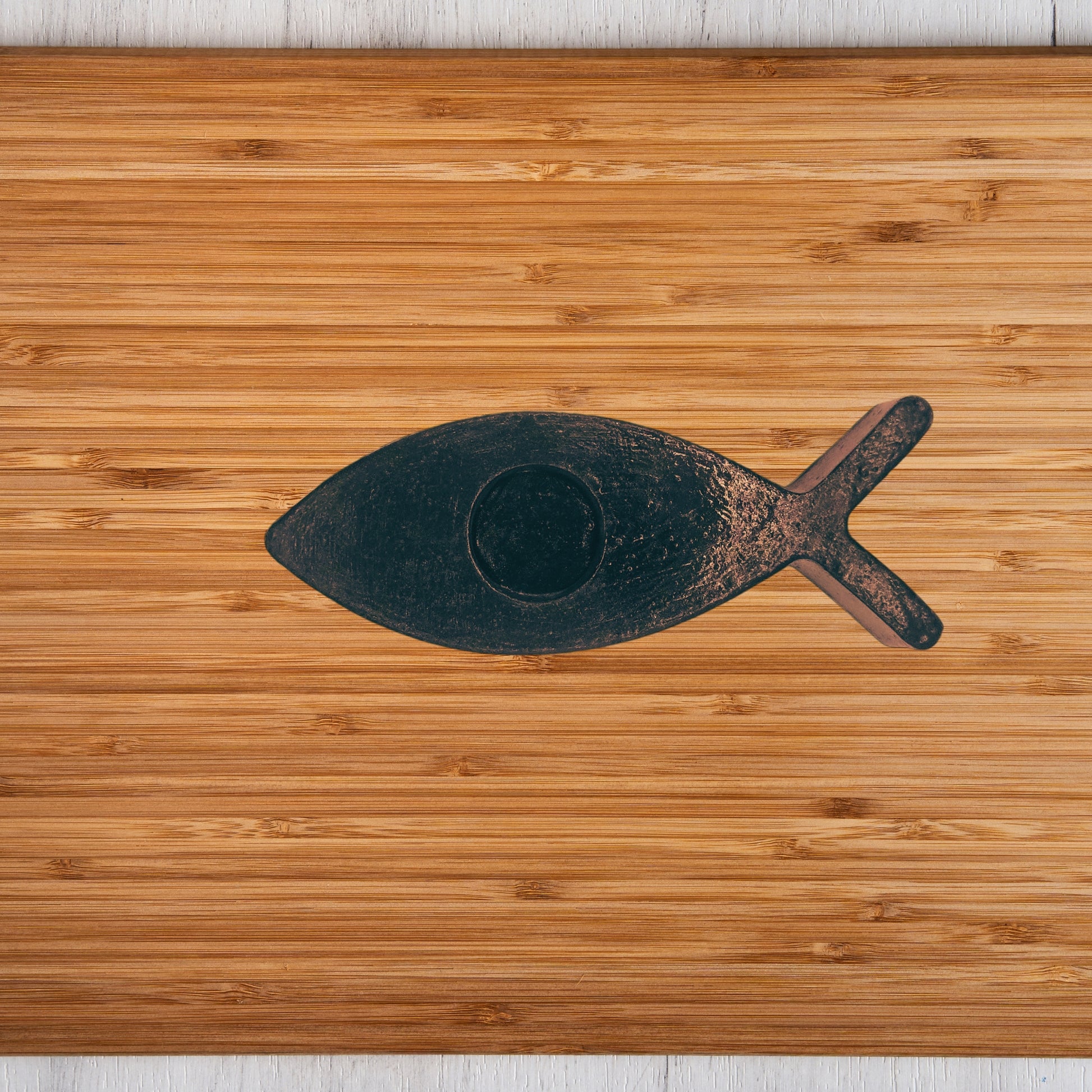 Black fish candle holder on a wooden surface