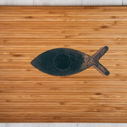 Black fish candle holder on a wooden surface