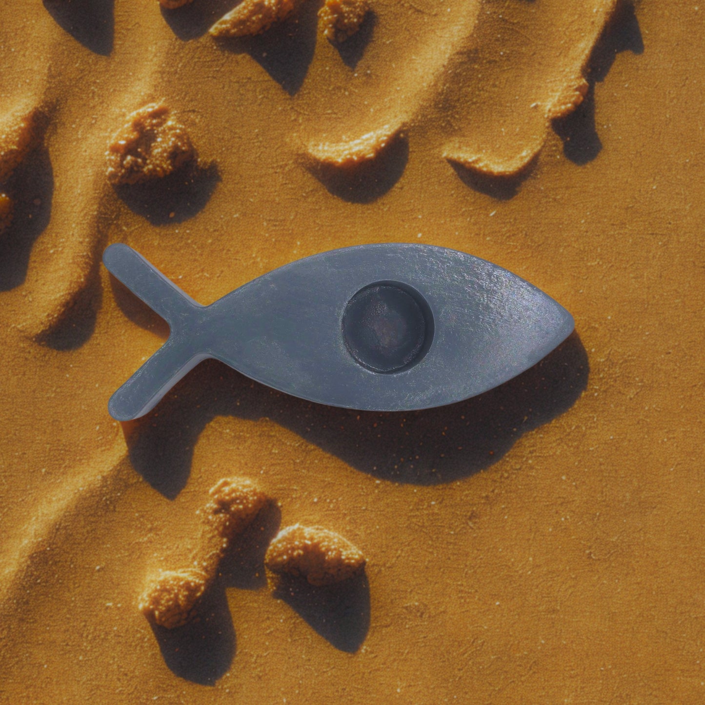 fish candle holder on a textured brown surface