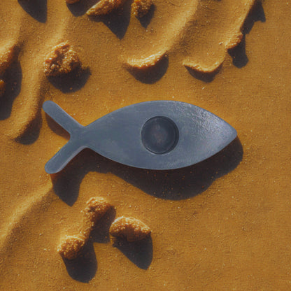 fish candle holder on a textured brown surface