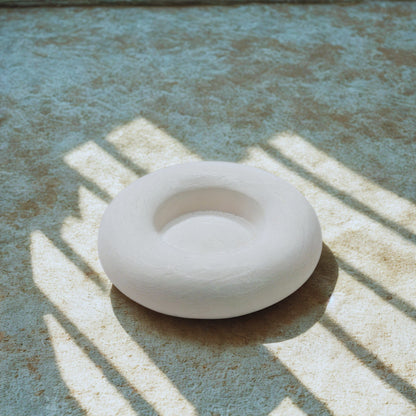 White object on a textured surface with shadows