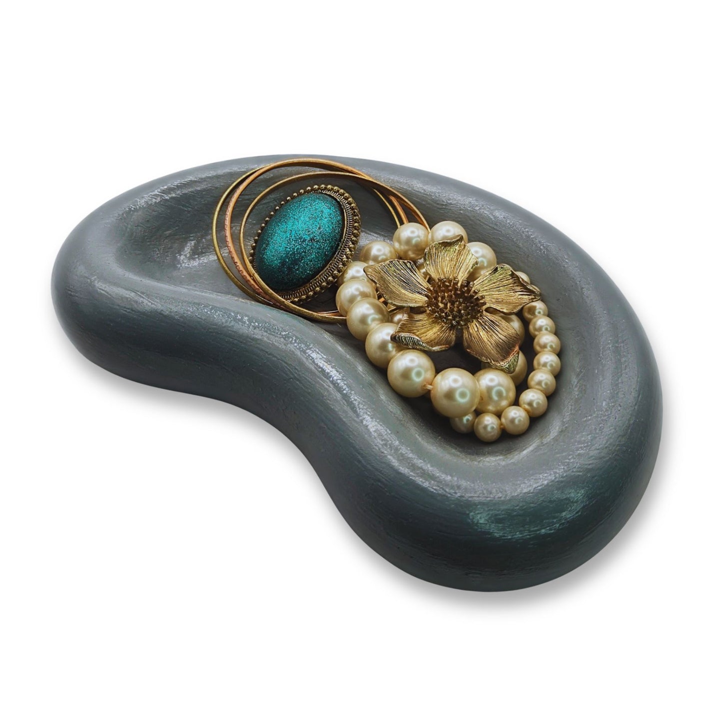 Jewelry set with a brooch and bracelet on a gray stone surface