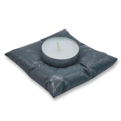 Candle in a gray cushion on a white background