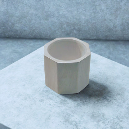Octagon tealight holder on a marble surface with a neutral background