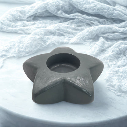 Star-shaped gray object on a textured white surface