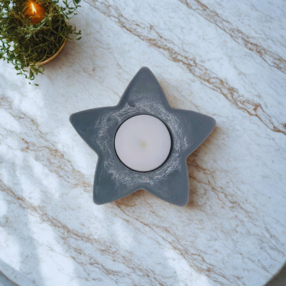 Star-shaped candle holder with a candle on a marble surface